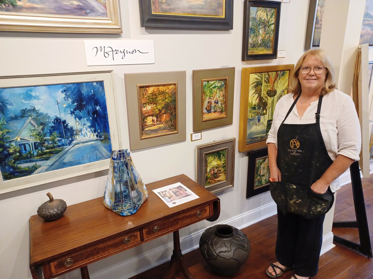 Martha Ferguson stands next to an exhibit of her new paintings at The Grand Bohemian Galley in St. Augustine.